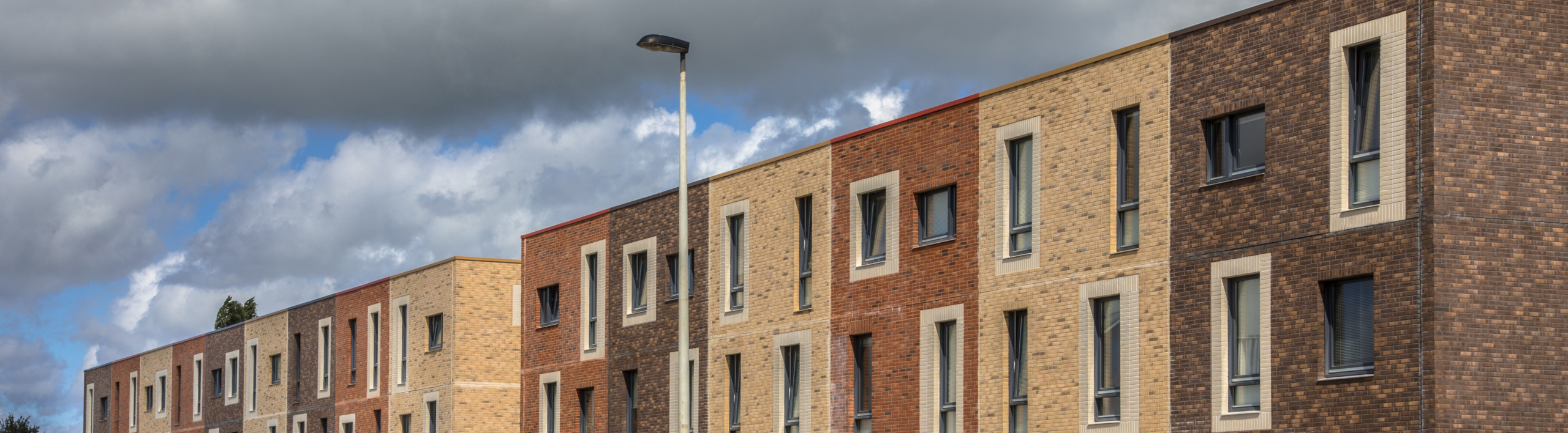 modern-brick-townhouses-in-urban-setting-on-sunny-2026-03-24-10-15-13-utc-scaled_2560x708_acf_cropped